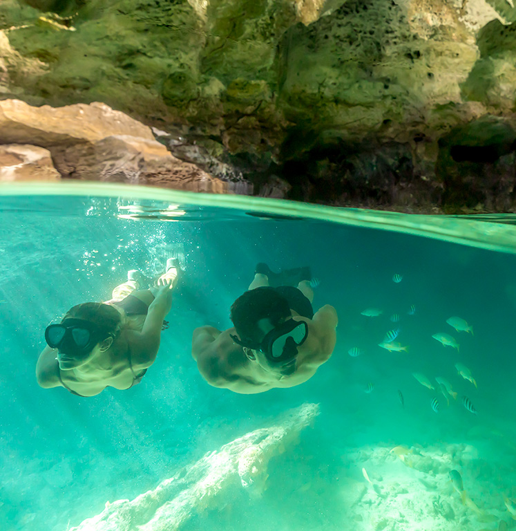 couple swimming snorkel in underwater caves