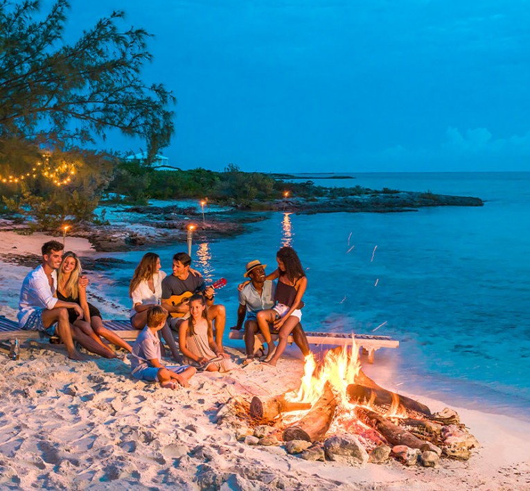Group of Men and Women around Bonfire on the Beach 